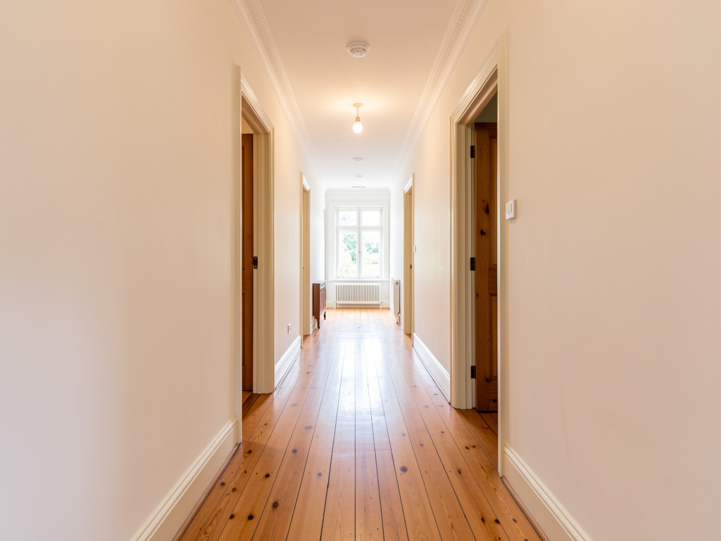 Clean painted hallway in a Melbourne home with timber floorboards and natural light