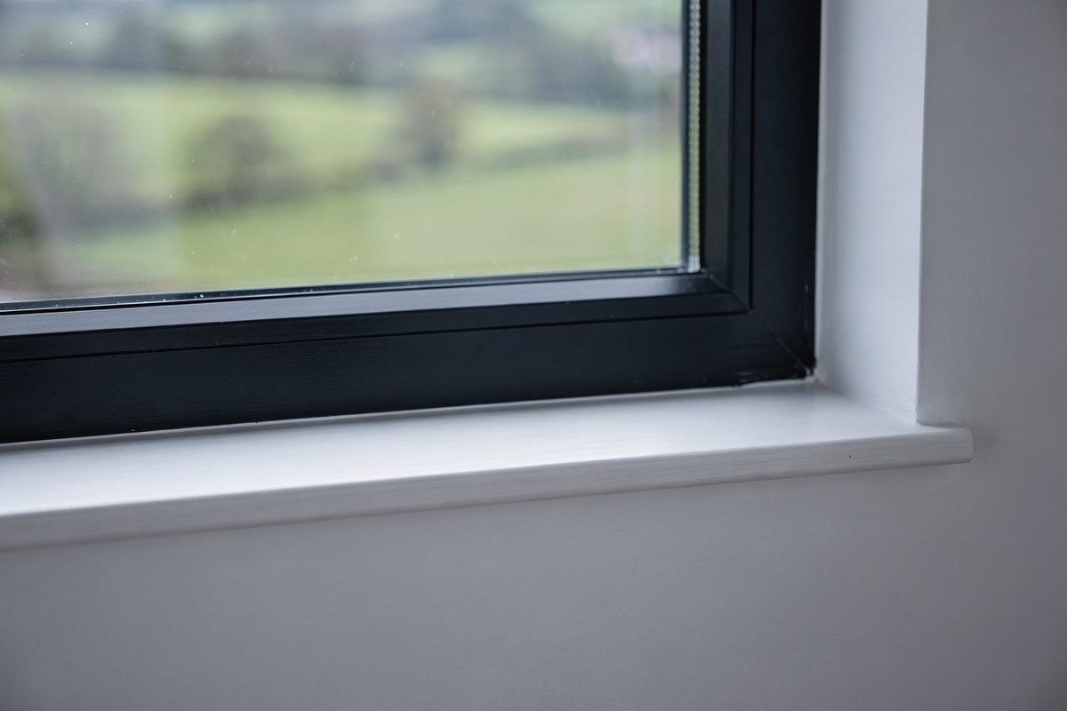 Freshly painted white window frame and reveal with clean sharp paint lines in an Aintree home