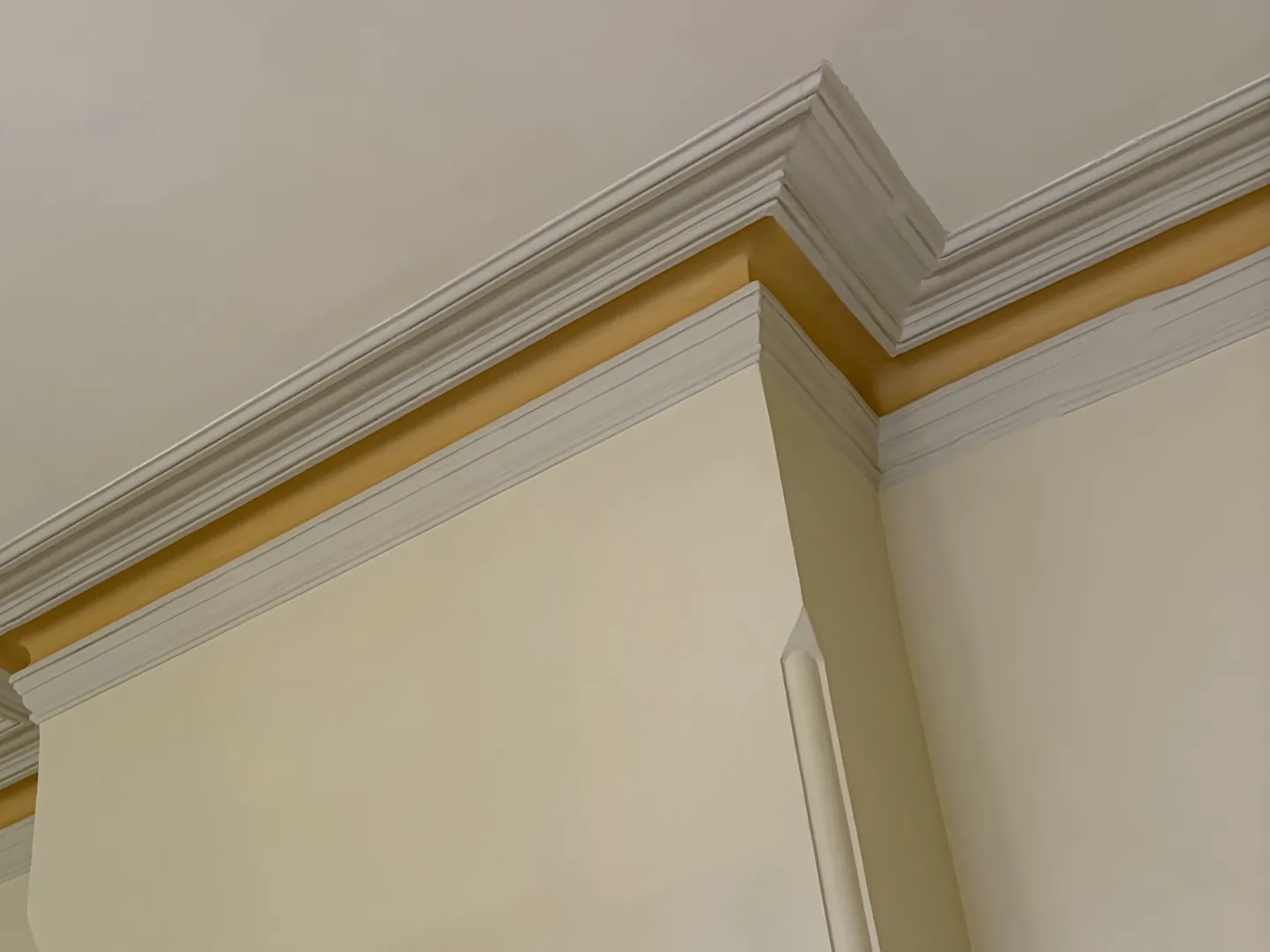 Two-tone cornice stepping around a chimney breast in a period room, painting for Albion homes