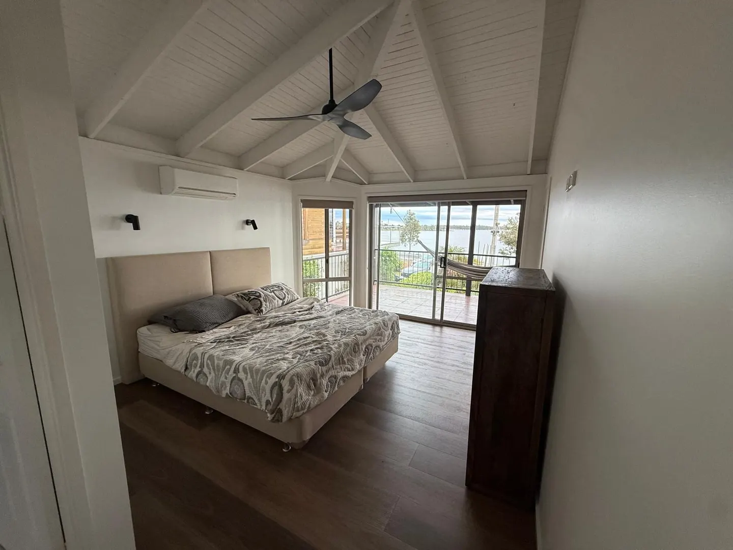 Bedroom with raked timber-lined ceiling and walls repainted by interior painters