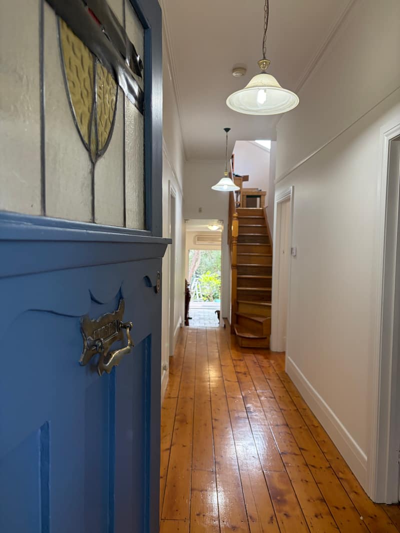 The same entry hall after painting, front door finished in deep blue
