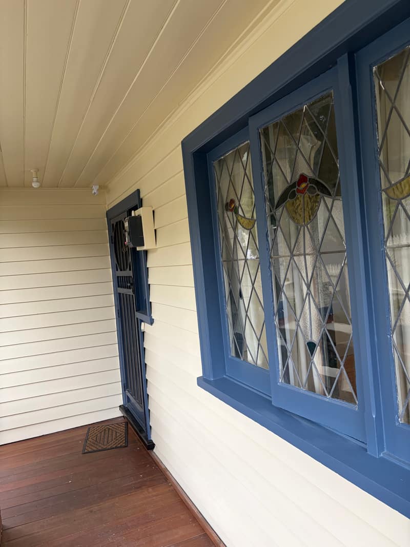 The same verandah repainted, leadlight window picked out in deep blue