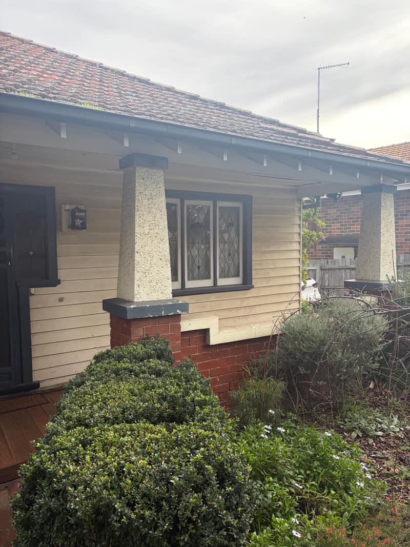 Tired weatherboard verandah and leadlight window before painting in Melbourne