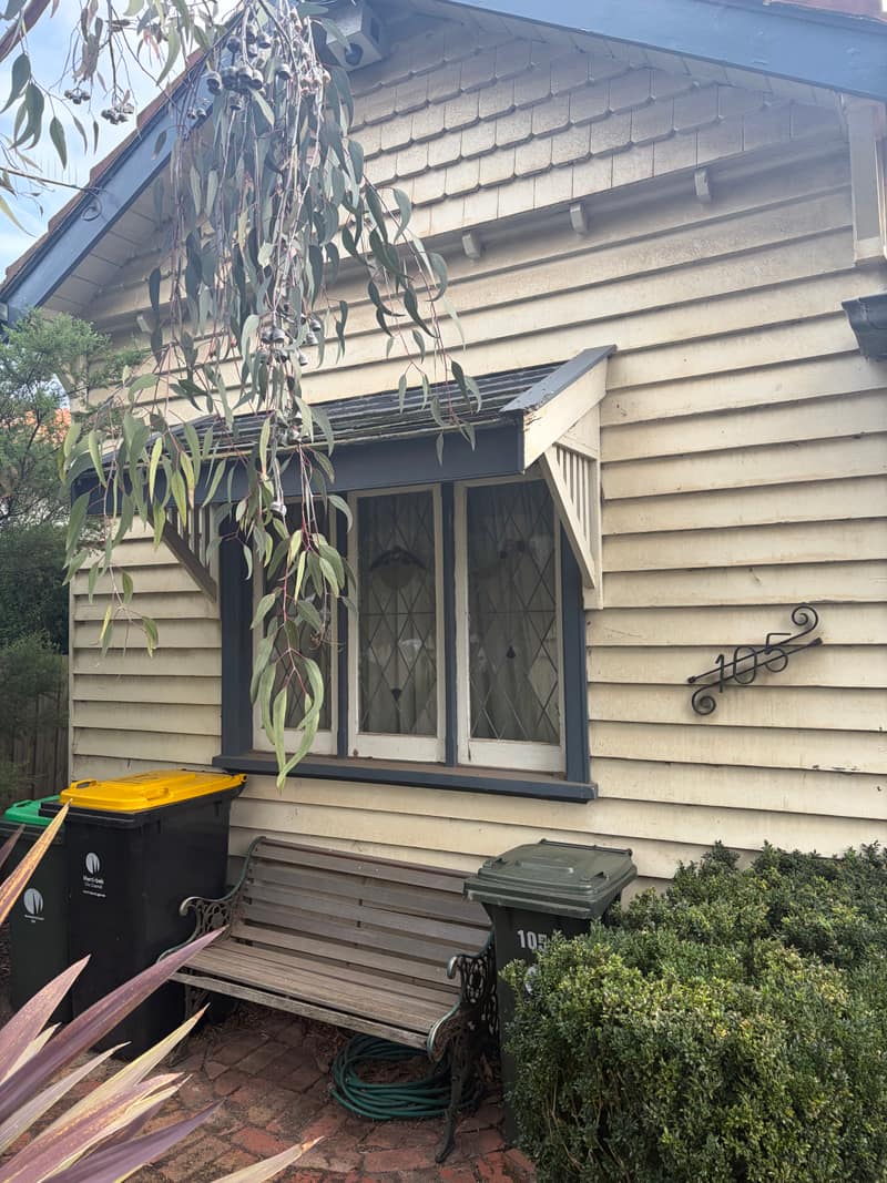 Chalky weatherboards and leadlight window before exterior painting