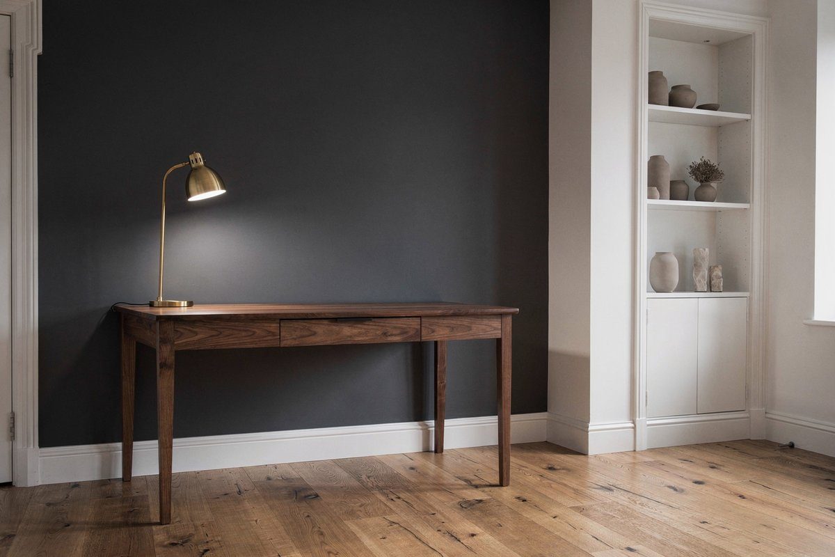 Home office with charcoal grey feature wall, timber desk, brass lamp and white built-in shelving in a renovated Williamstown home